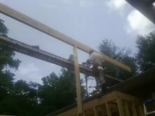 Carpenter setting a ridge beam over a new addition frame — Ice Dam Removal by Roofing Brothers in Mechanicsville