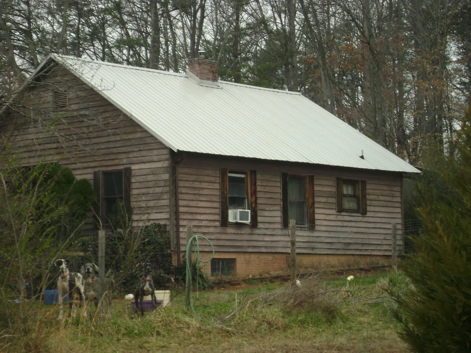 White metal roof on an old wood sided farmhouse, from a Metal Roof Installation job in Mechanicsville